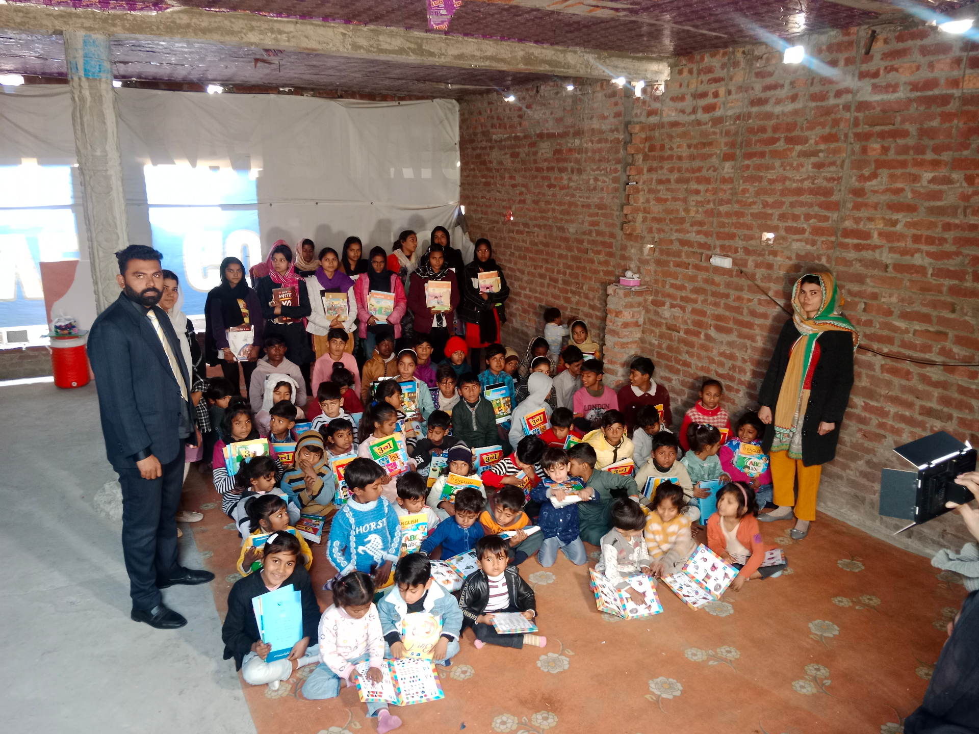 Group of children receiving books and stationary