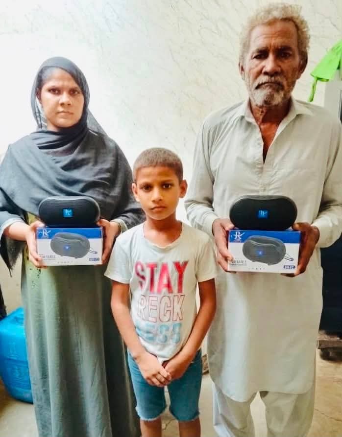 An elderly widow in Pakistan holding her new portable Audio Bible player