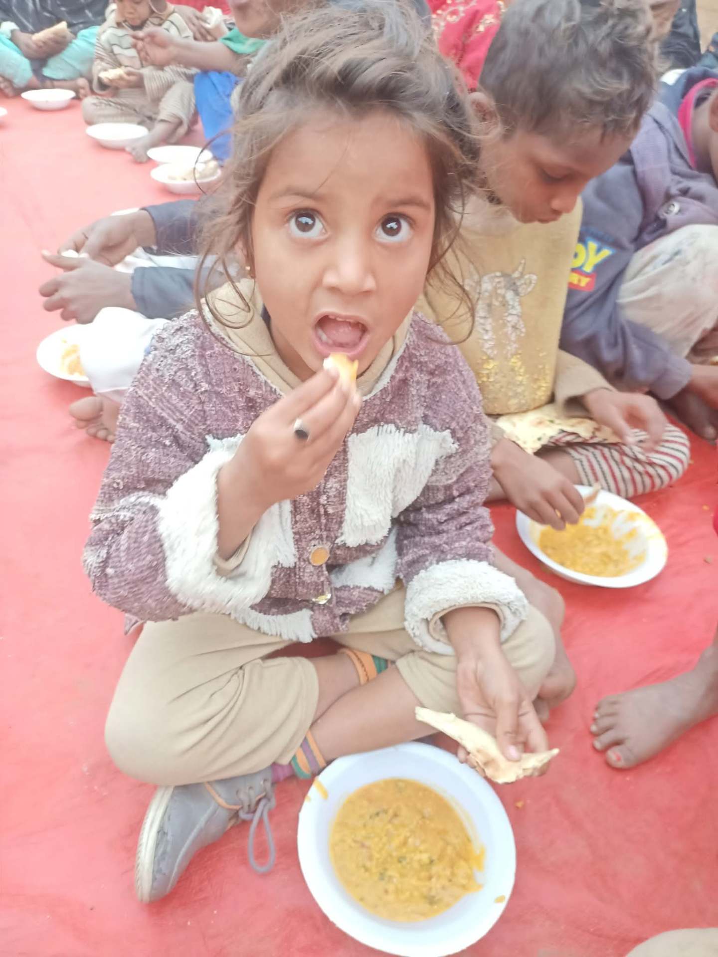 A hungry child receiving a hot meal
