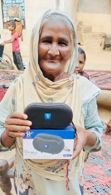 A mother with her baby and an elderly neighbour receiving Audio Bibles