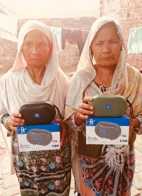 An elderly couple standing together with their Audio Bibles